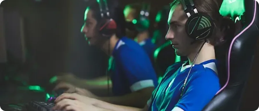 Professional eSports players wearing headsets and focused on live competitive gameplay.